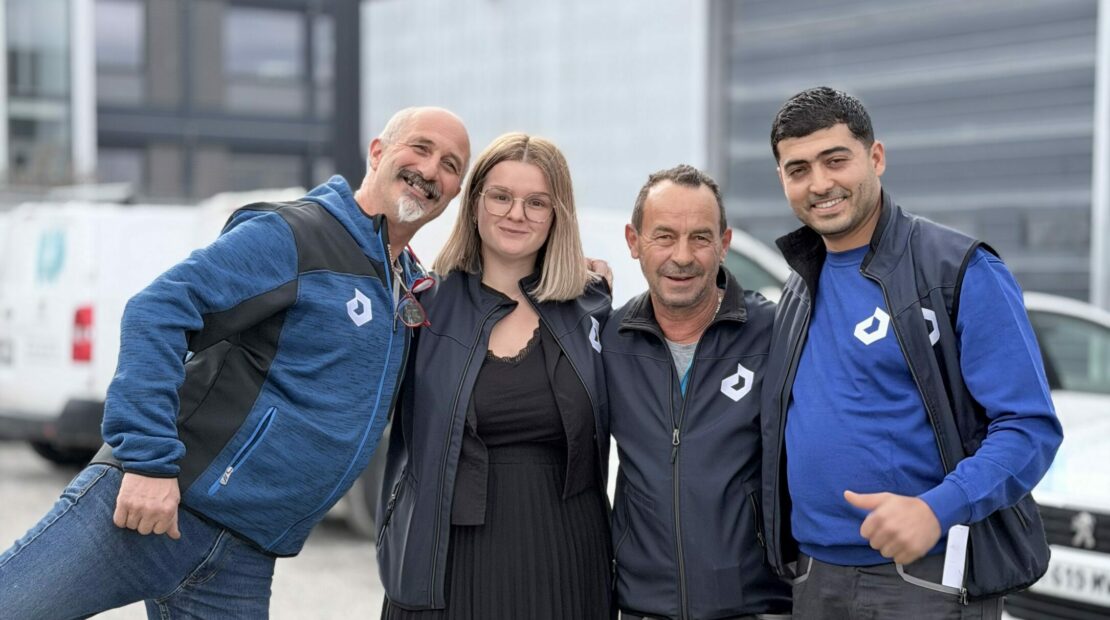 Photo de l'équipe dépannage et petits travaux chez duret electricite. Ils sont 4 devant les locaux de DURET ELECTRICTE à Annecy avec leur tenue de travail.